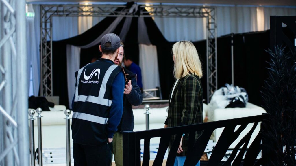 Event manager adjusting event plans with team at an event.