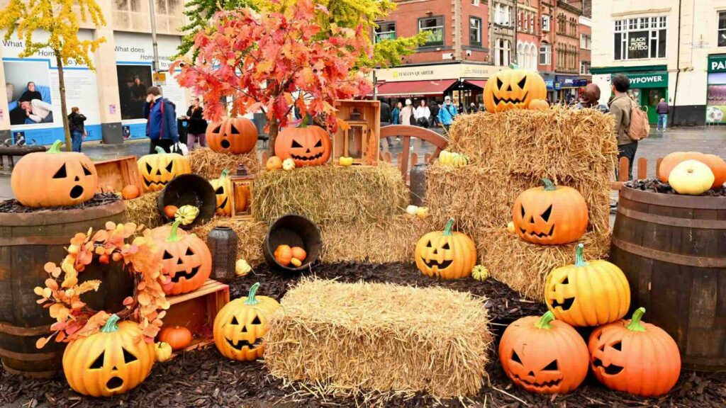 An outdoor installation for Halloween with pumpkins and hay bales.