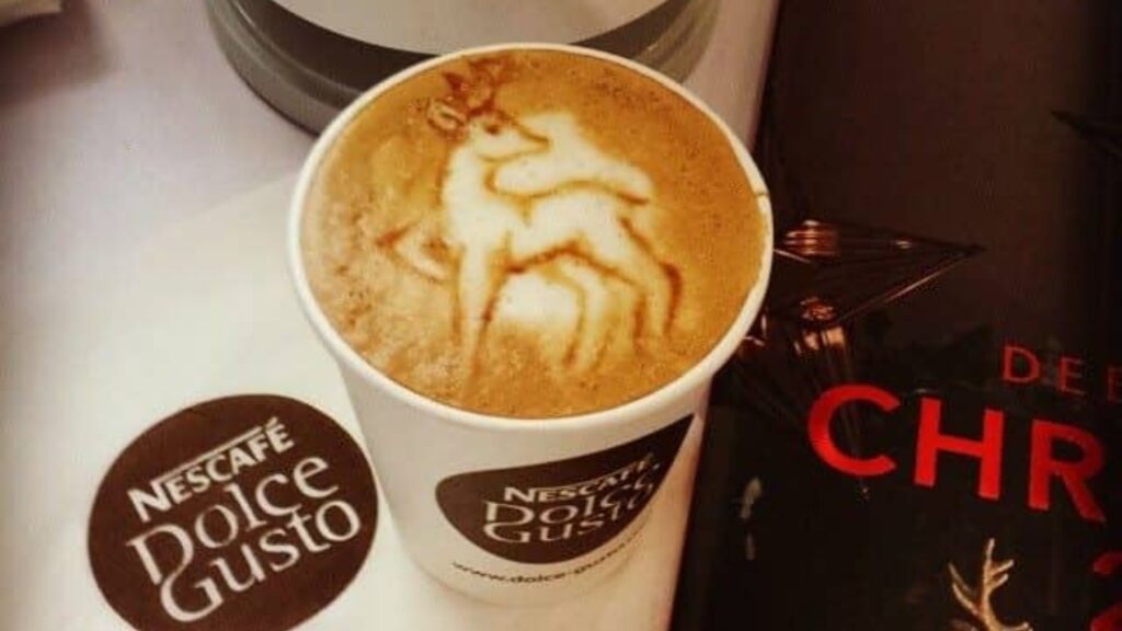 A Christmas coffee with a reindeer artwork on the top of the coffee.