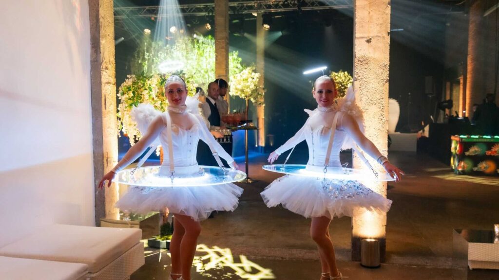 Two LED Christmas themed human tables serving champagne.