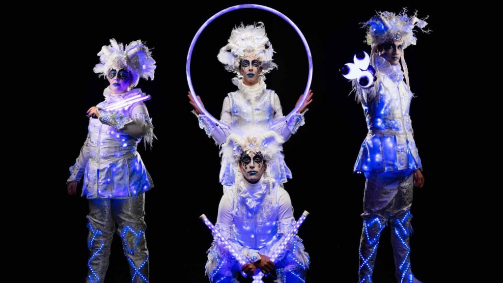 Christmas themed LED performers with hoops and white costumes.