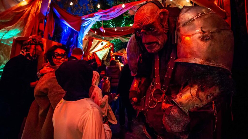 A giant troll character interacting with guest at a Halloween brand activation.