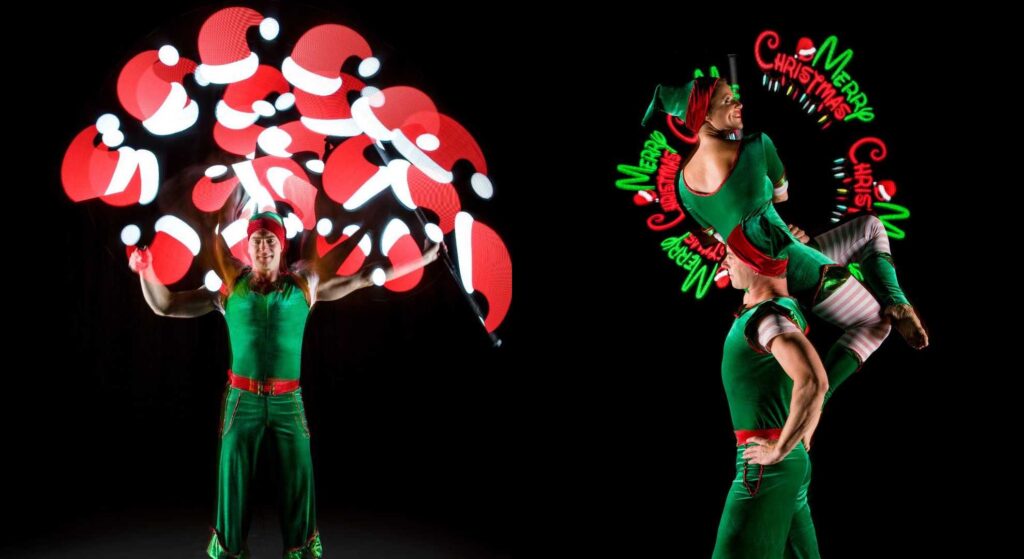 LED Christmas elf acrobats using 3D projection such as Santa hats and Merry Christmas slogans.