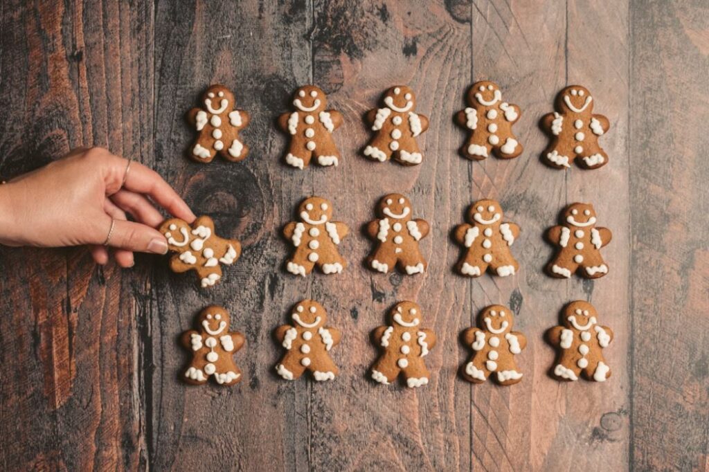 Gingerbread men laid out on a wooden table.