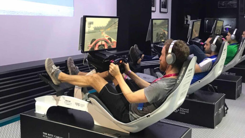 Colleagues competing on a motorsport simulator for sales kick off events.