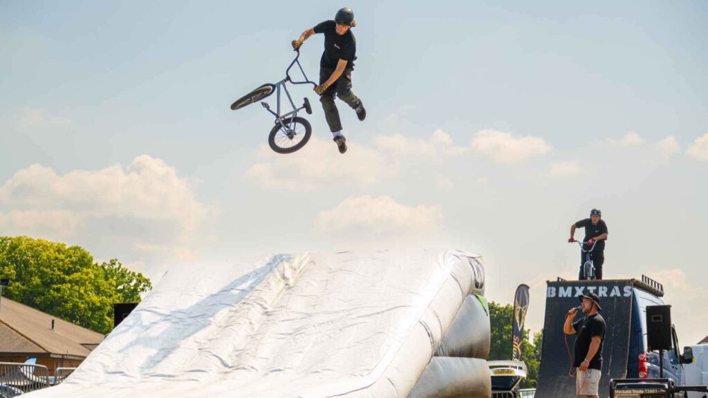 A BMX rider mid-air after jumping off a ramp.