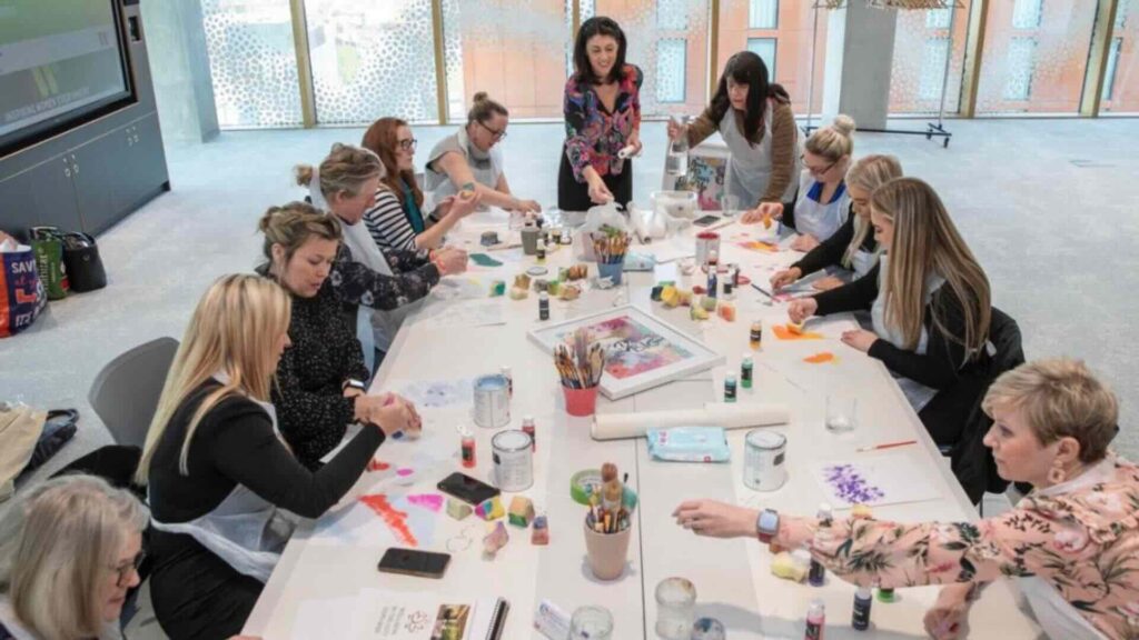A wellness workshop indoors with attendees making crafts.