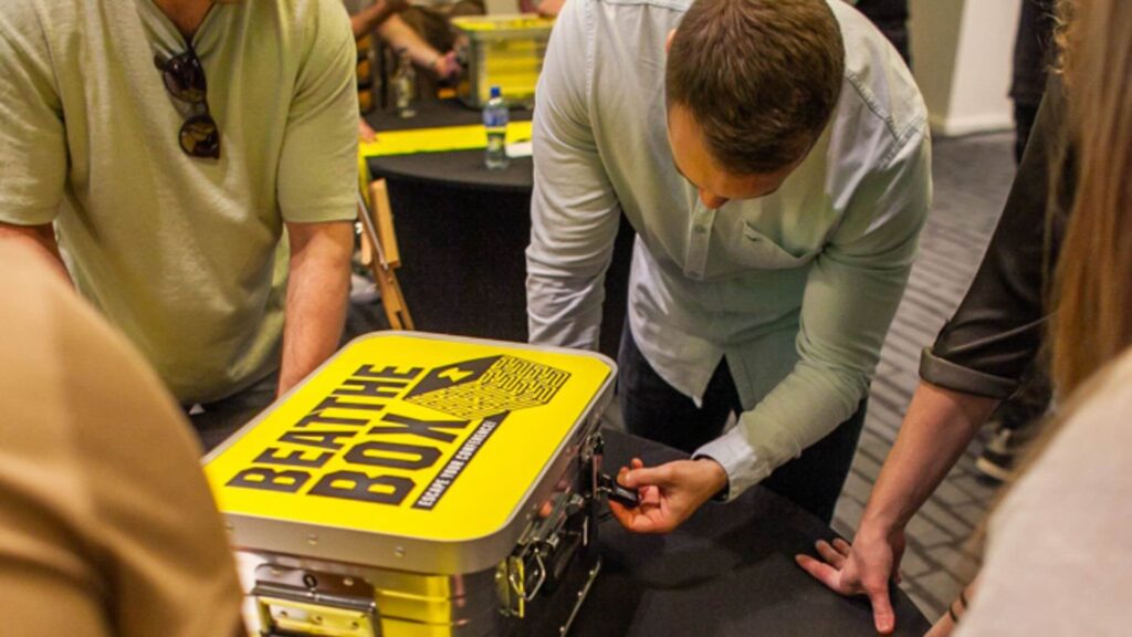 A group of teammates working to open up a mystery box