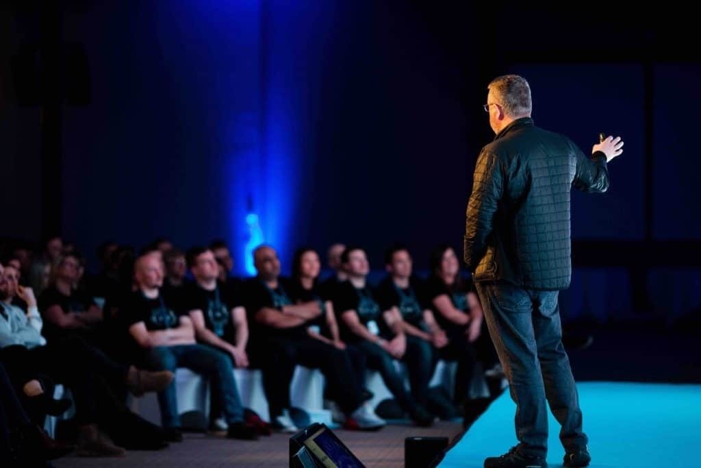 A speaker on stage at a Xero conference sales kick off event.