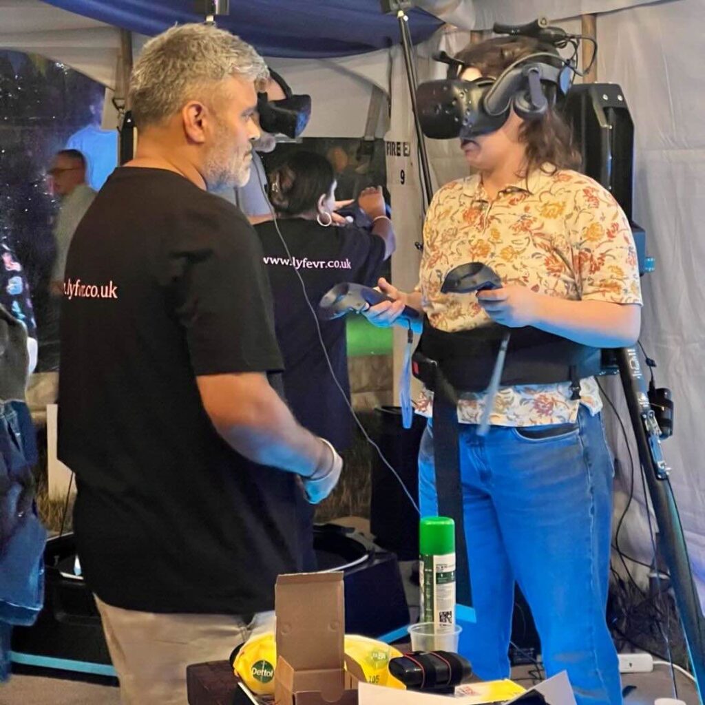 Someone participating in a VR treadmill experience while someone teaches them the mechanics.