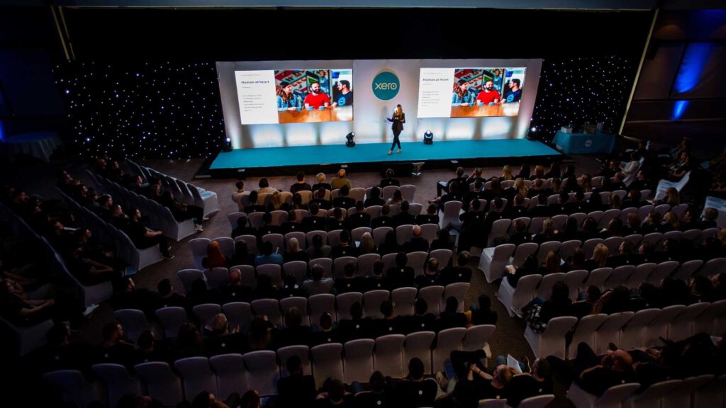 Guest speaker in stage at an Revenue Kick Off inspiring audiences.