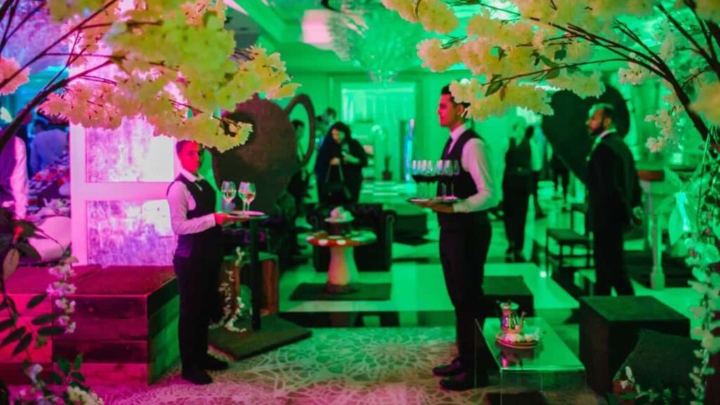 Event caterers greeting guests at the entrance of a product launch event.