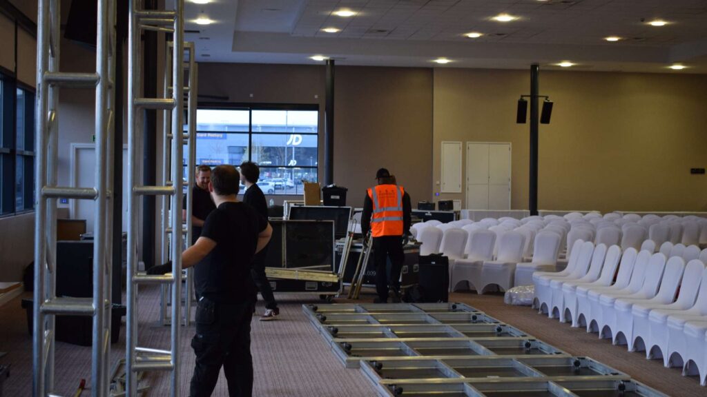 Production team setting up a conference area at MK Dons stadium in Milton Keynes.