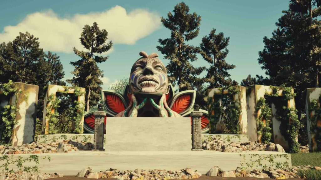 A large stone sculpture of a human face with exaggerated features and a headdress, surrounded by lush greenery and towering trees, designed for festival themed events.