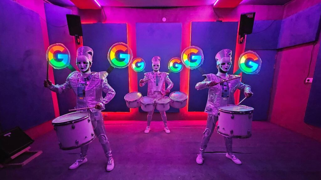 LED drummers performing with google logos on their holographs.
