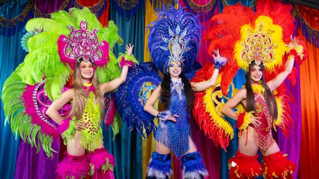 An assortment of our Brazilian style carnival acts posing for a photo in vibrant attire.