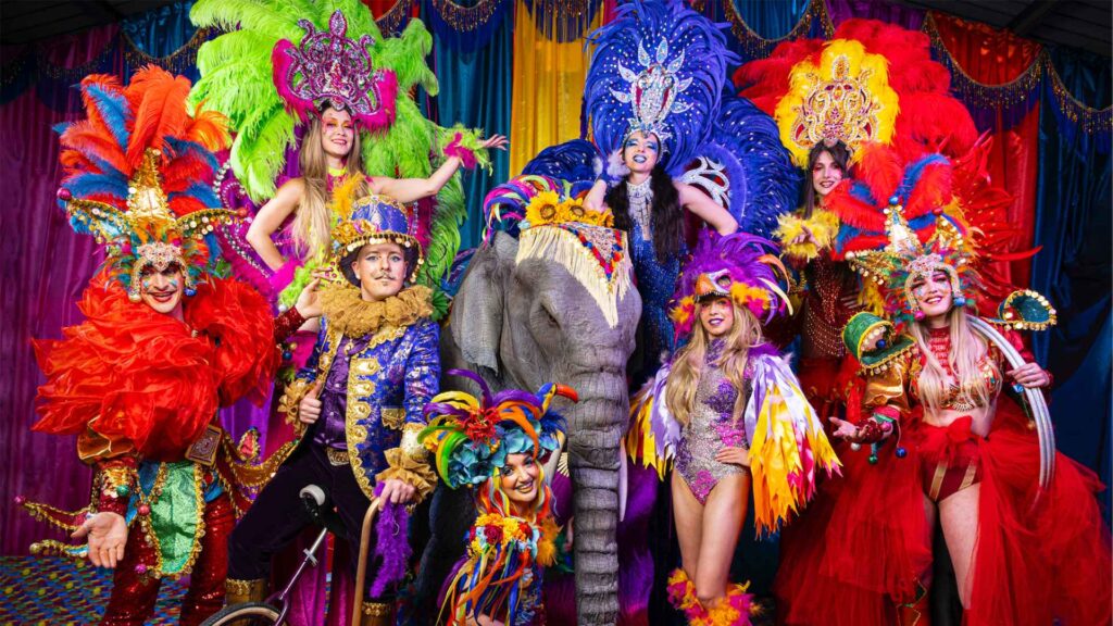 An assortment of our Brazilian style carnival acts posing for a photo in vibrant attire.