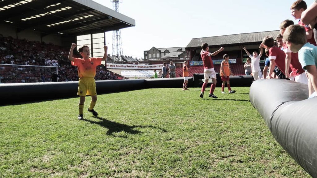 Children participating in football games within this inflatable pitch.