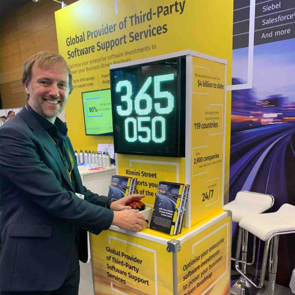 A man smiling next to our stop the clock game machine.