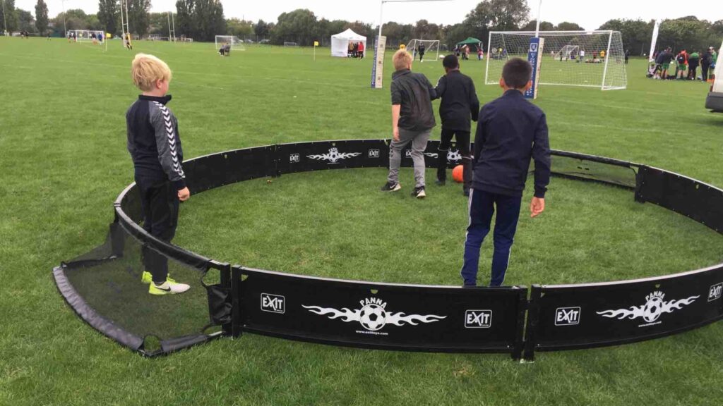 Kids participating in a panna arena at an outdoor event.