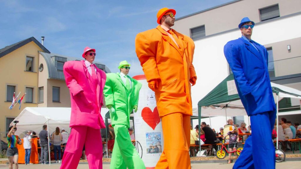 Family friendly walkabout entertainers creating fun interactions for guests at a summer festival.