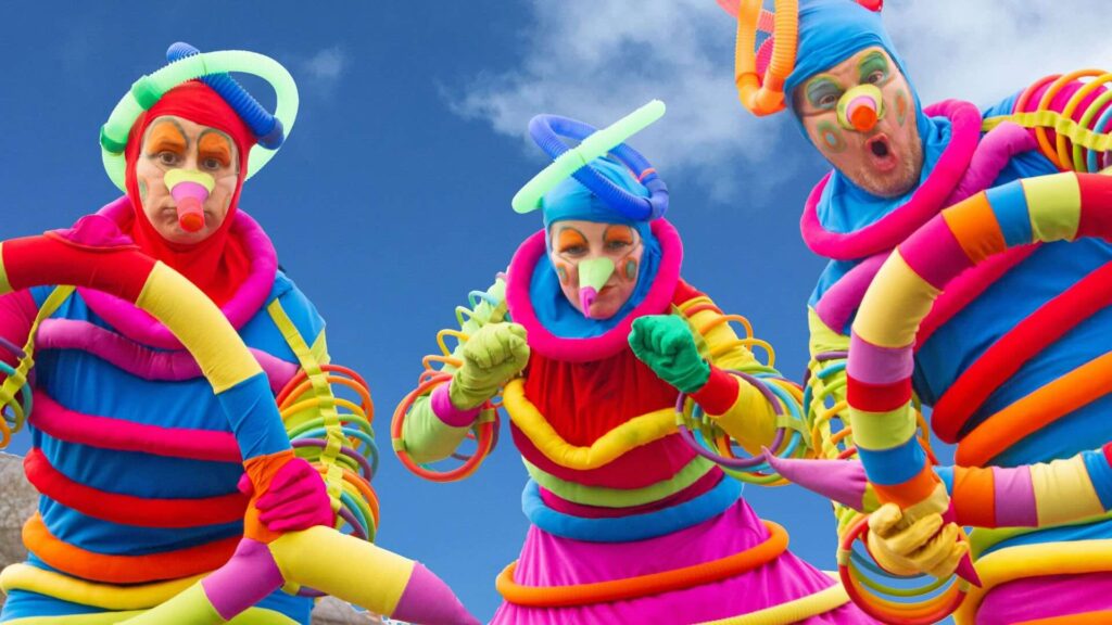 Colourful stilt walkers ready to entertain families at a summer outdoor festival.