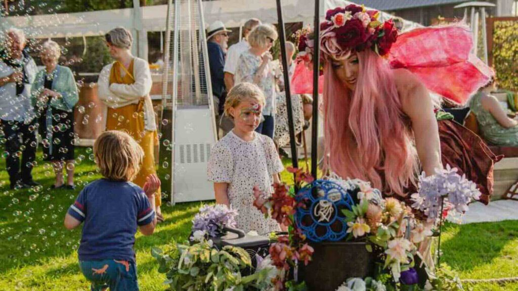 Enchanted forest fairy walkabout entertainers interacting with families at summer event.