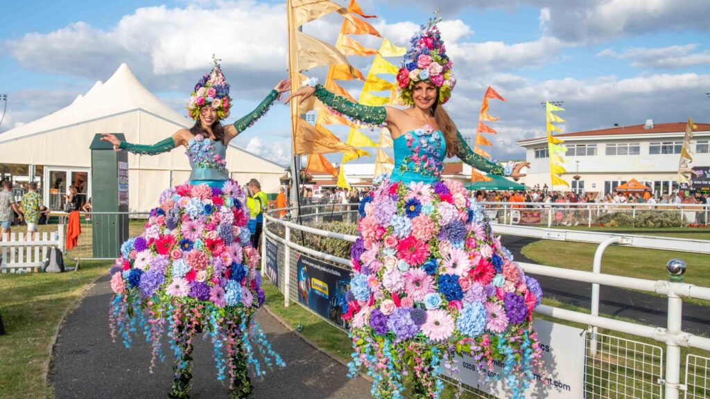 Luxury floral stilt walkers towering above families at a family fun day.