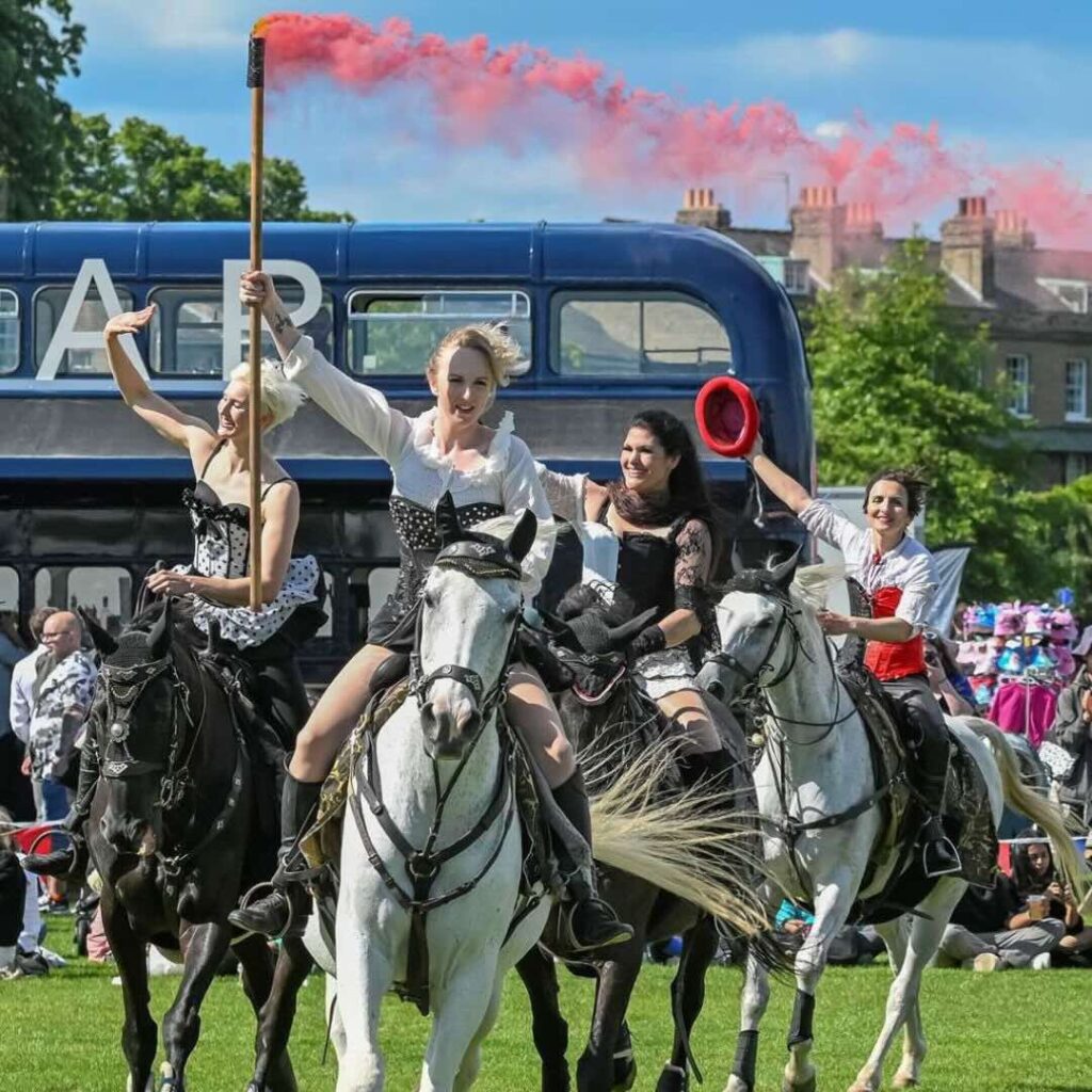 Equestrienne stunt show with riders performing riding on field.