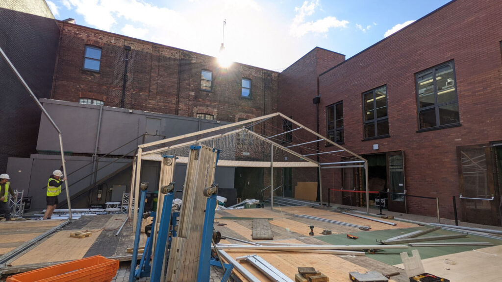 An outdoor shot of a warehouse location with a brand activation being built.