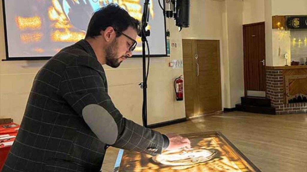 A sand artist putting on a globally understood storytelling show with sand at a conference.