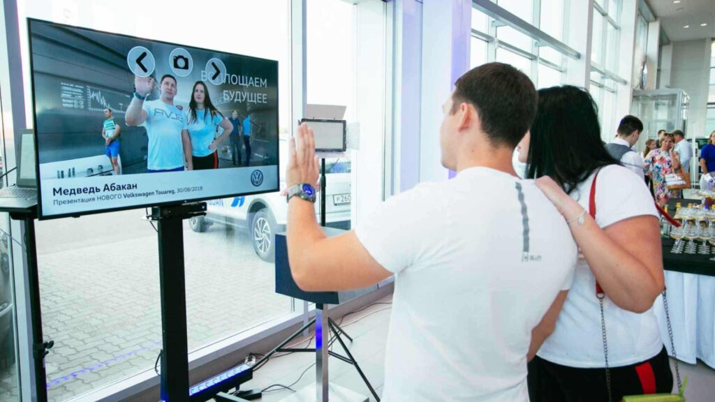 Guests checking in on digital welcome screen at an event.