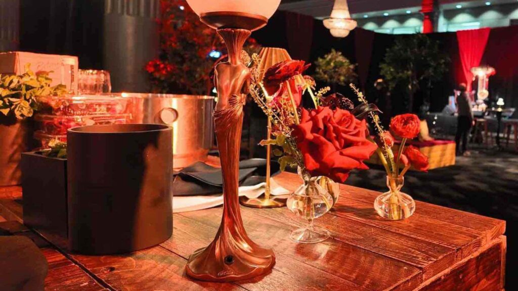 Art deco event lamp in gold with red flowers.