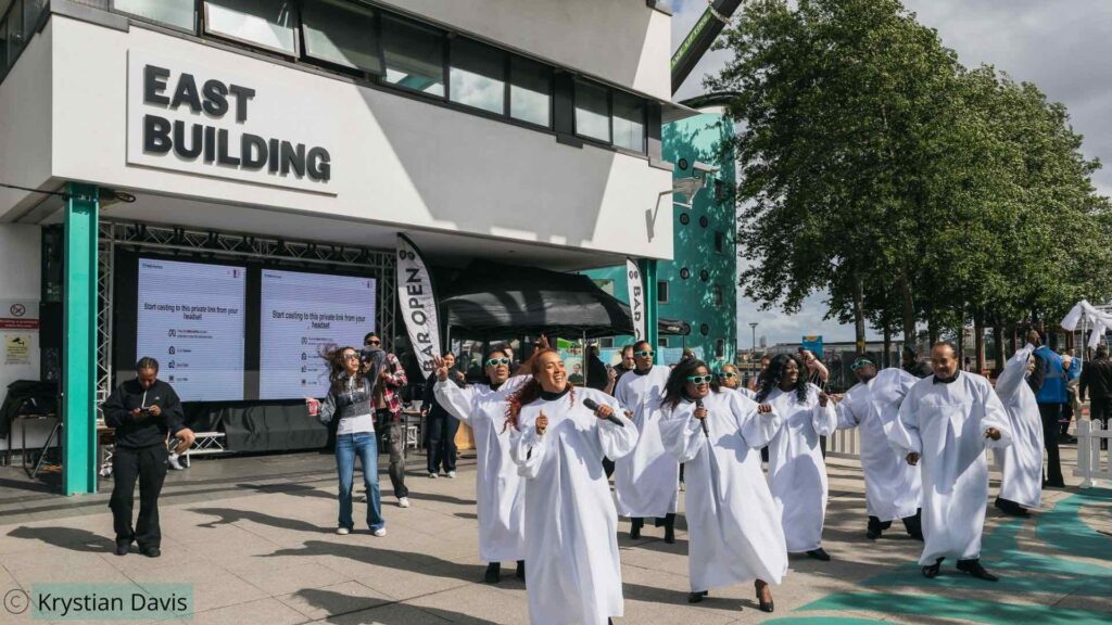 Immersive gospel choir performing outside of East Building at UEL campus in London as part of a bespoke show production.