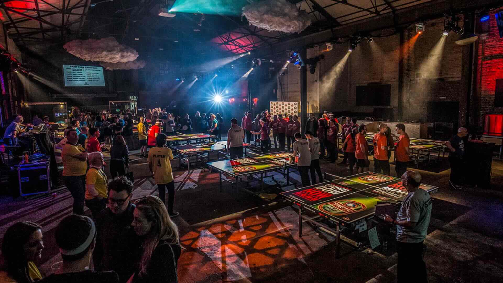 A ping pong team building event with a large crowd at a corporate event.