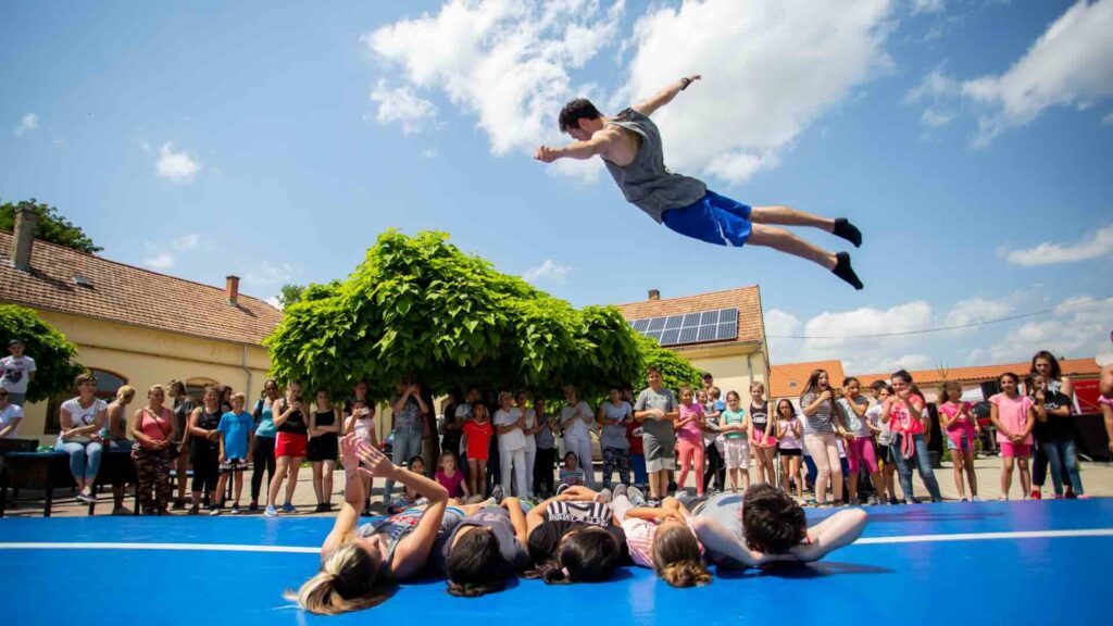 Air track acrobat performer flipping high above an event crowd