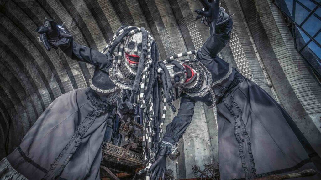 Two of our Burton inspired Halloween performers posing for photos at a creepy location with dark braids and masks.