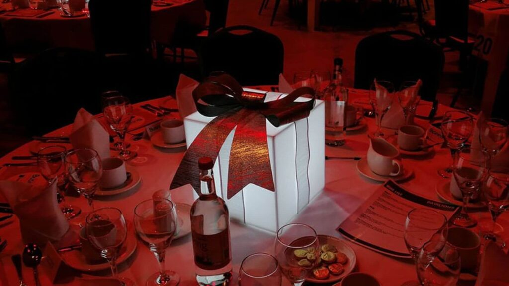 A table centrepiece designed around a red gift, perfect for Christmas events.