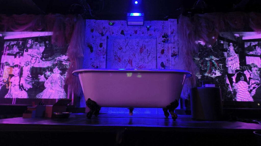 Large white bathtub prop used alongside stage production.