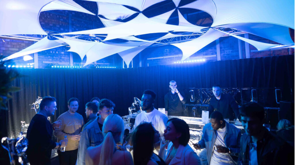 Launch party with branded bars and guests interacting with product displays
