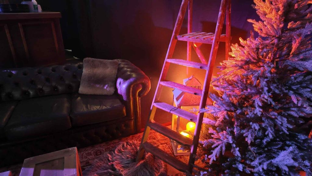 Alpine set design with vintage stepladder, lantern and flocked pine at a corporate Christmas party