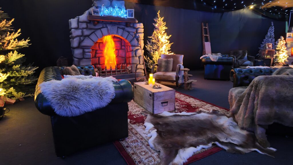 Alpine fireplace lounge with chesterfield sofas, sheepskin throws and hide rugs at a corporate Christmas party