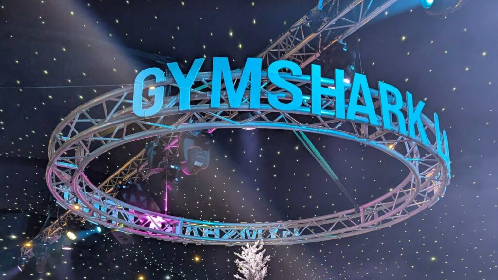 Suspended circular truss ring with Gymshark lettering above a corporate Christmas party