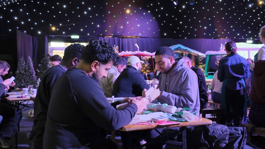 Guests making Christmas crackers at a workshop during a corporate Christmas party