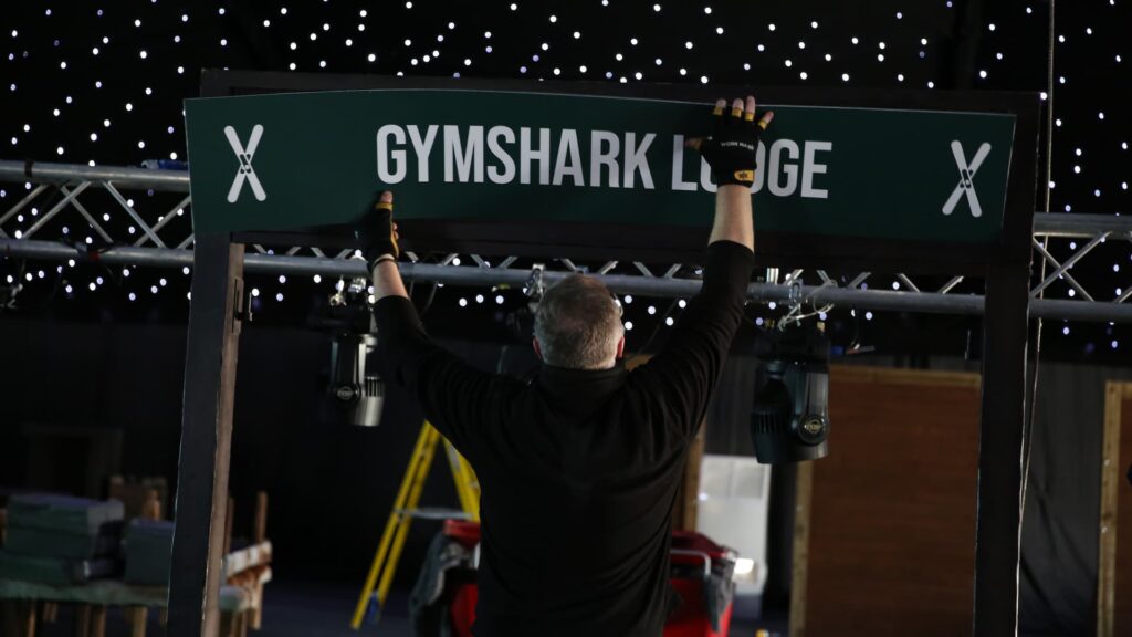 Branded lodge signage being fixed into the entrance frame.
