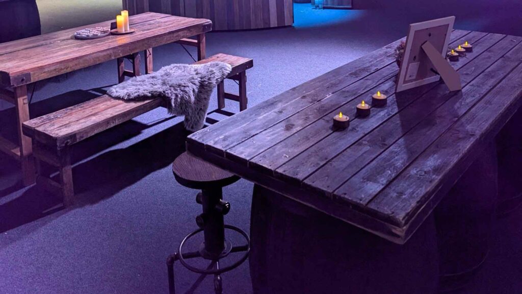 Rustic trestle tables and benches with sheepskin throws at an Alpine Lodge themed corporate Christmas party