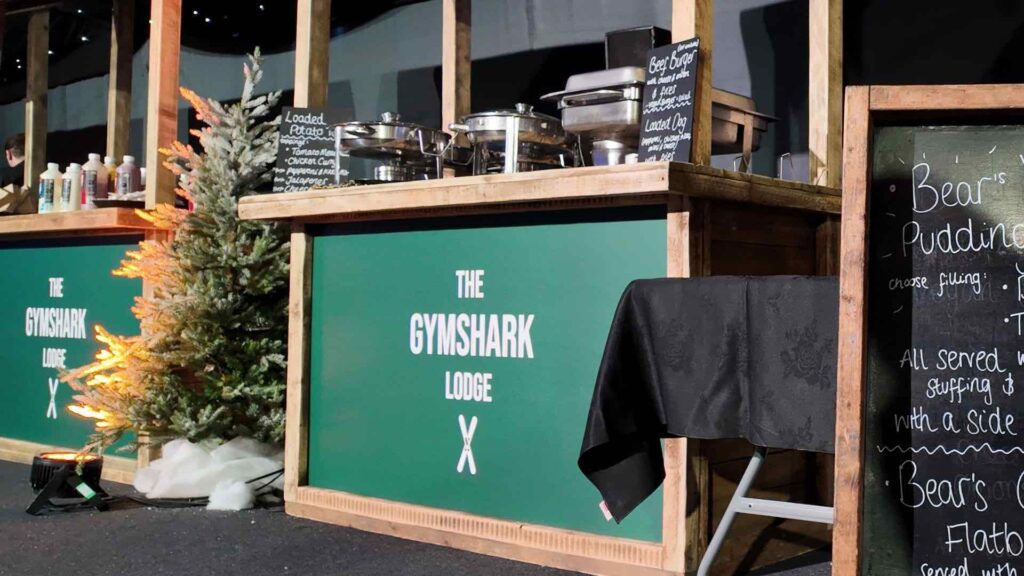 Branded food stalls with The Gymshark Lodge panels at a corporate Christmas party