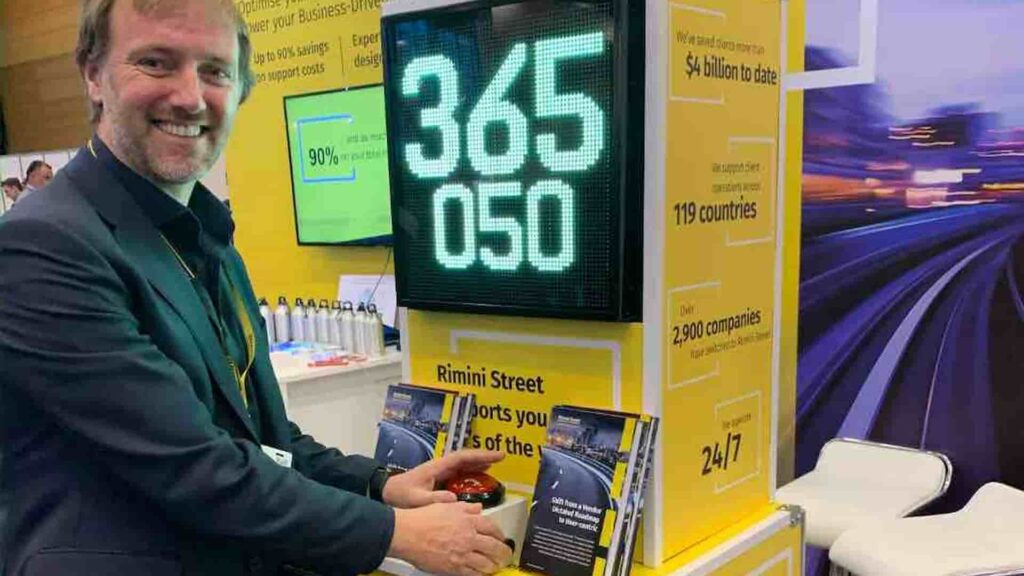 Visitor pressing the button on a stop the clock reaction game built into a branded exhibition stand