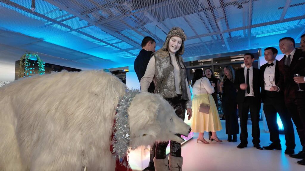 Life-sized polar bear walkabout act entertaining guests at a corporate Christmas party