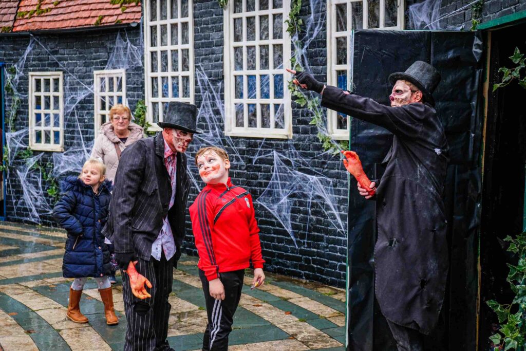 Halloween performers interacting with children at the Trick or Treat Street set in Southport town centre